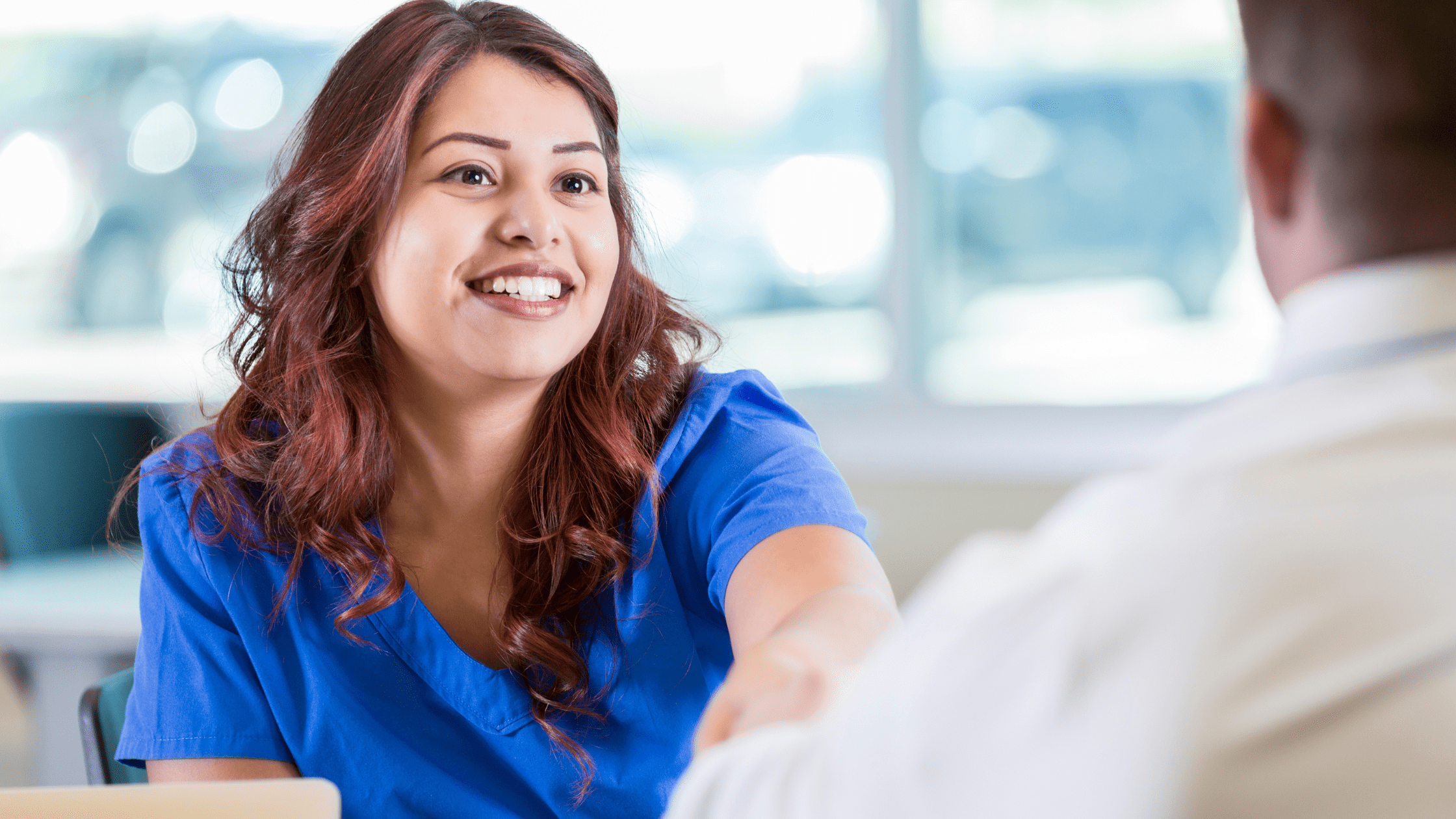 A potential resident shaking hands with their interviewer.